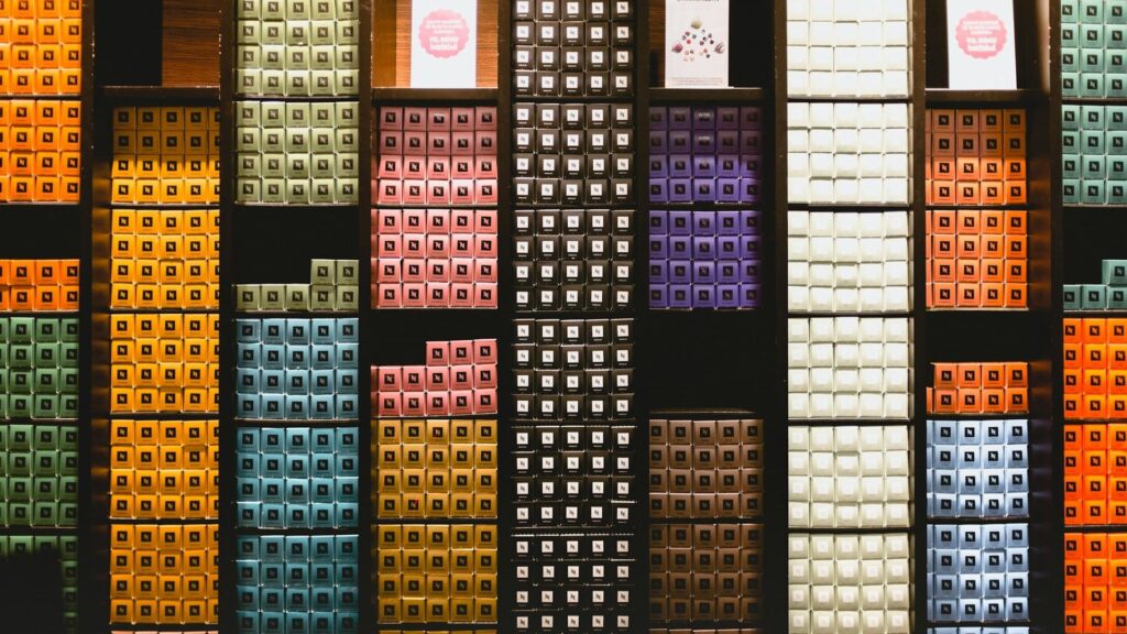 Nespresso-capsules in kleurrijke, perfect geordende vakken tonen een visueel voorbeeld van orde en netheid.